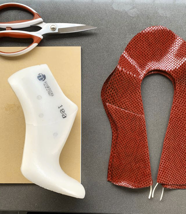 Close-up of a leather upper and last with scissors, showcasing the craftsmanship behind En Talons shoes, made in Italy.