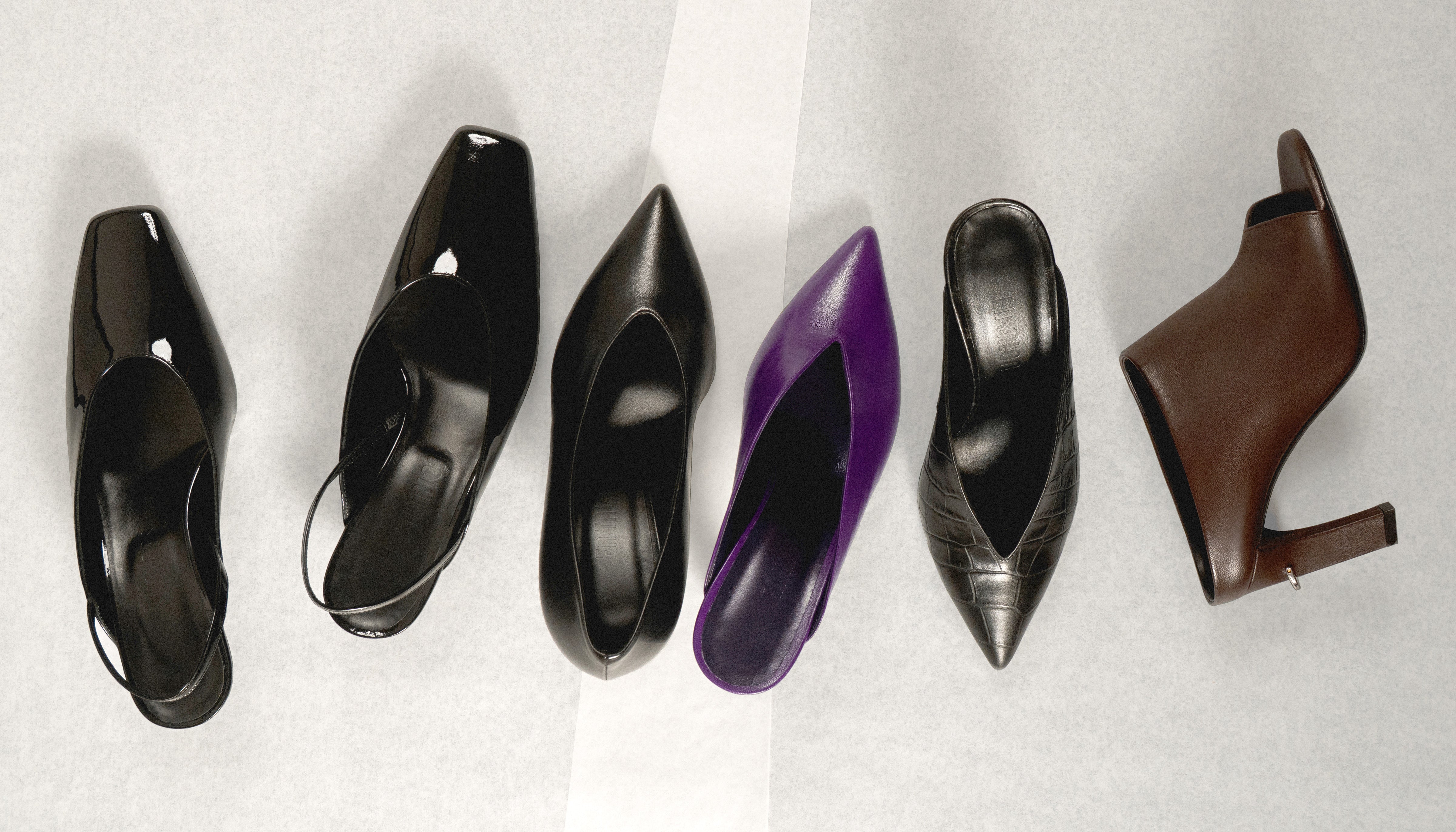 Set of black, purple, and brown high-heeled shoes on a neutral background